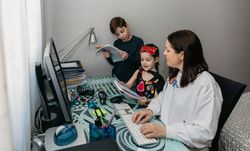 Woman teleworking and reviewing her children's homewor