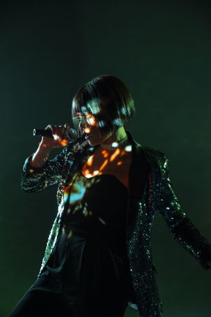 Stylish woman singing on stage