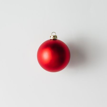 Single red Christmas bauble on light background