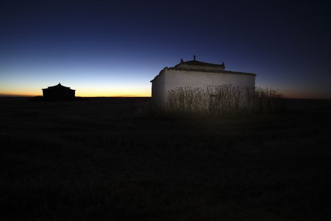 Aged house in rural countryside under starry sky