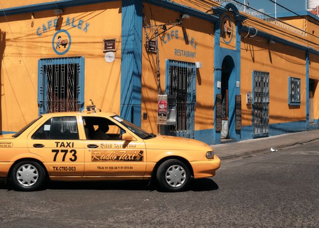Taxi driving next to restaurant in Oaxaca