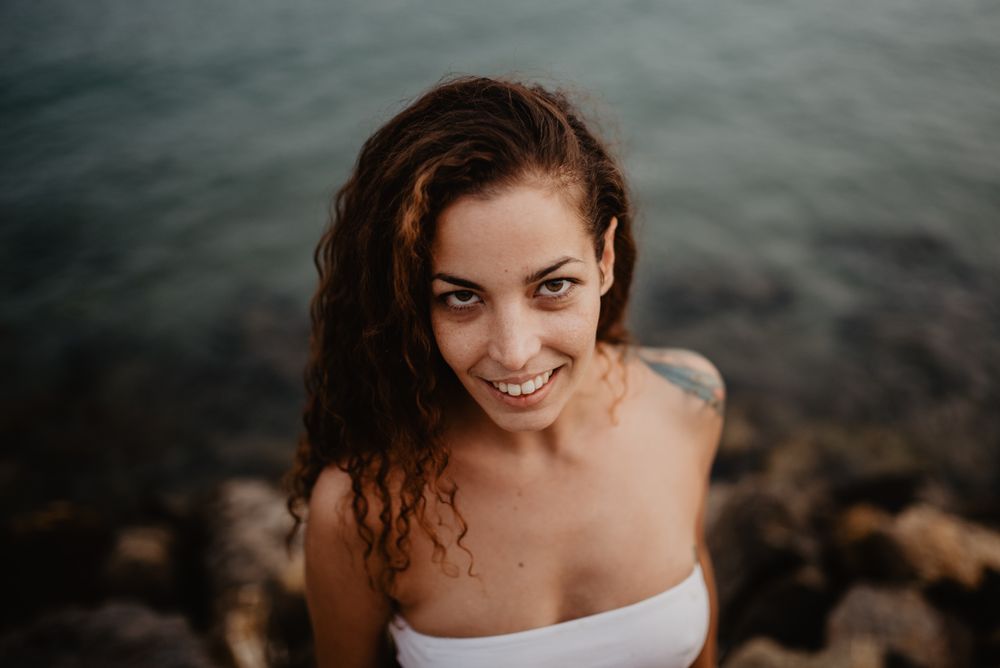 Smiling woman standing near sea