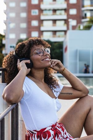 Black woman listening to music near water