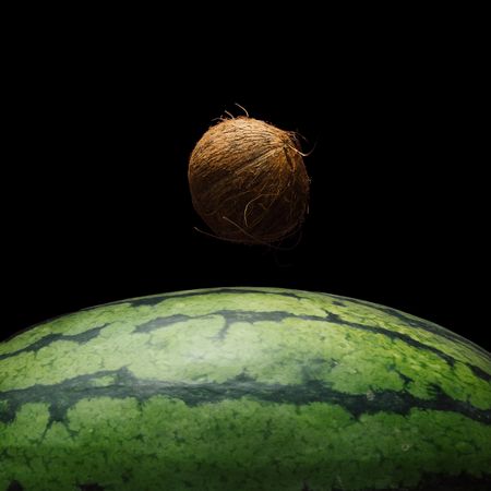 Space scene with watermelon and coconut in place of the earth and moon