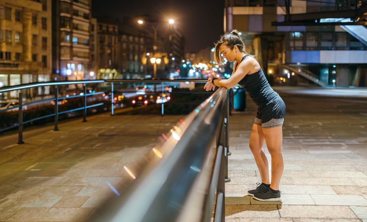 Blonde runner woman checking exercise progress on smart watch application after training