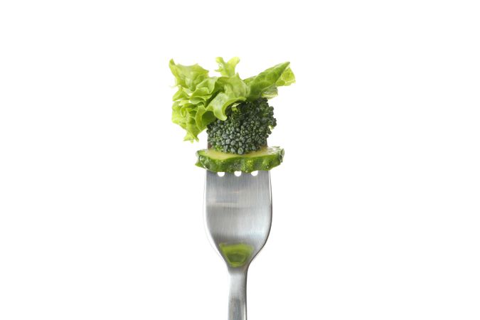 Fork with salad, cucumber and broccoli isolated on blank background