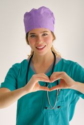 Cheerful medical worker making heart gesture on gray backdrop