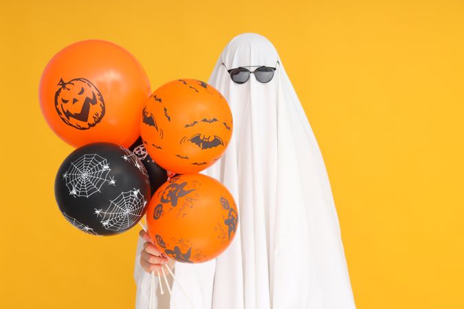 Concept of Halloween, Ghost with Halloween balloons on yellow background