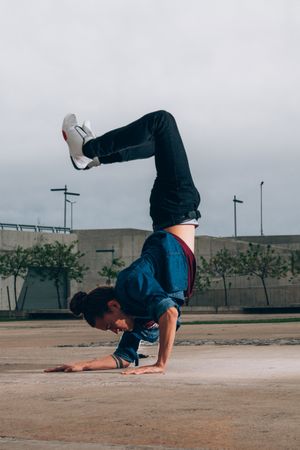 Skillful break dancer performing handstand while moving