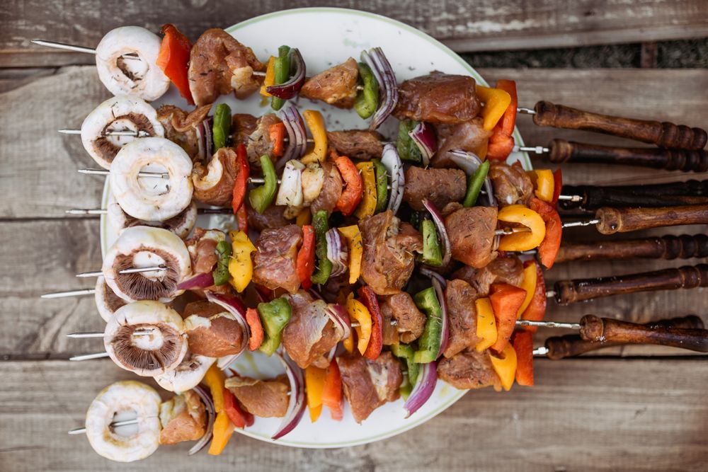 top view of plate with skewers sticks of pork with vegetables