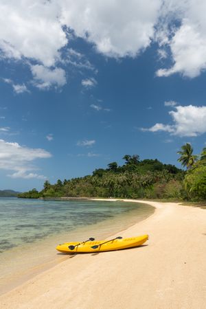 Kayak on sandy beach of tropical shore
