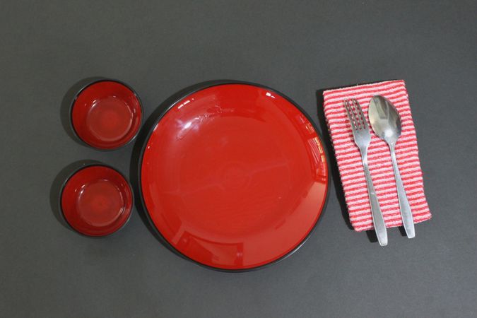 Table setting with red plates and other cutlery