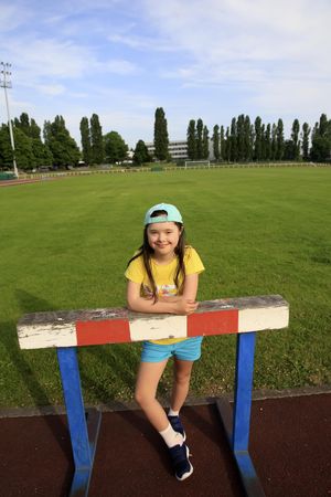 Young child resting on a track and field hurdle