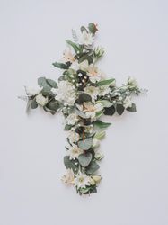Easter layout with flowers and leaves in cross shape on light paper background