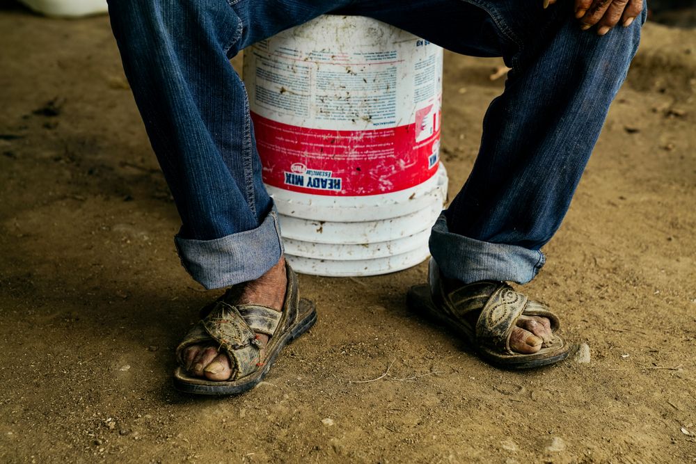 adult man resting on bucket