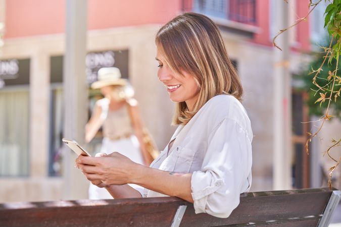 Positive female browsing phone on street
