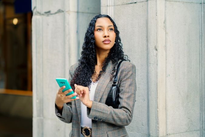 A Stylish Woman Engaged with Her Smartphone in a Vibrant Urban Setting, Captivating Attention