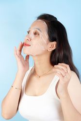 Indonesian Asian Young Woman Applying Paper Sheet Facial Mask