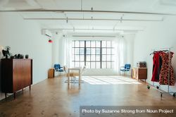 Wide shot of urban loft with large window and minimal furniture 47lBOb