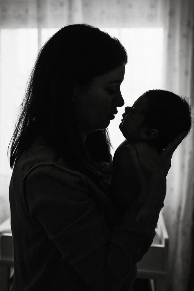 Mom holding newborn on hands at home