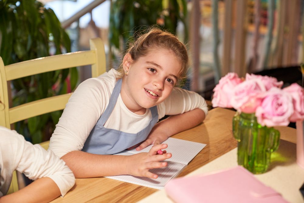 Attentive girl sitting at table at school