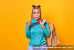 Surprised Muslim woman smiling with shopping bags and credit card 5k77L5