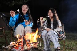 Two Asian Friends Camping and Making Smores at Campfire