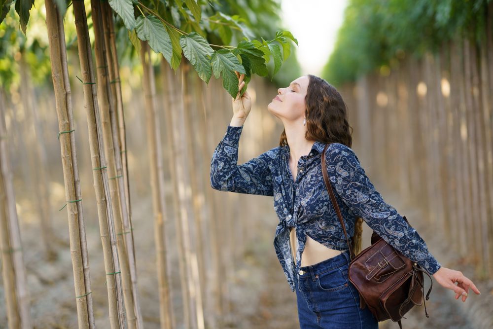 A woman is joyfully enjoying the beauty of nature in a picturesque vineyard setting