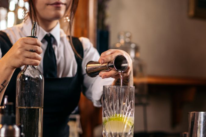 Female bartender preparing a cocktail in a traditional cocktail bar