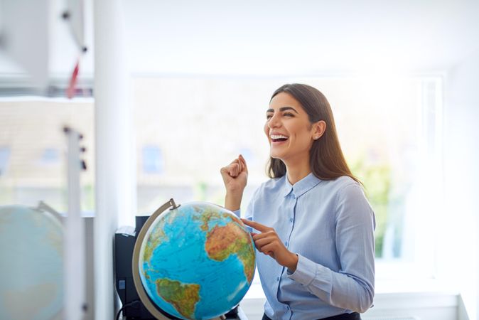 Smiling woman with hand on globe