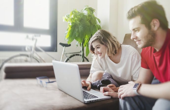 Couple browsing laptop on couch