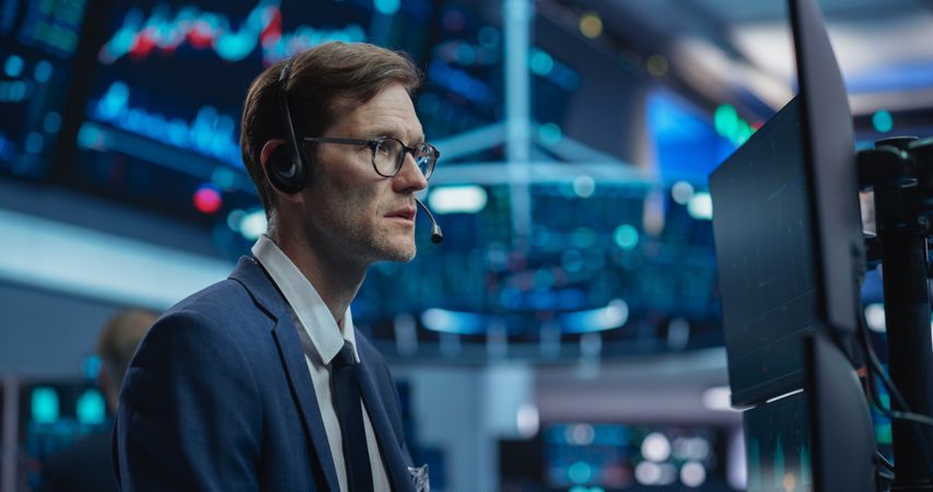 Stockbroker Talking with Business Clients on a Call, Working on Computer, Speculating on Buying Shares for Day Trading