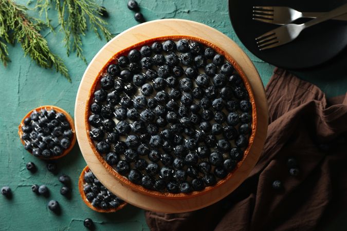 Concept of tasty lunch with blueberry pie on green background