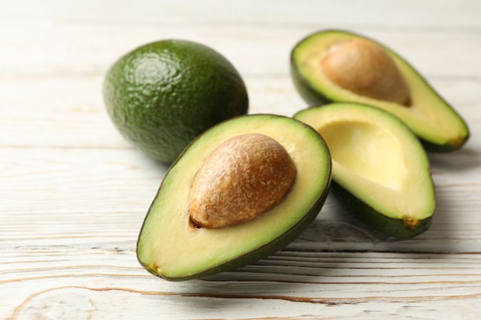 Ripe fresh avocado on wooden background, close up