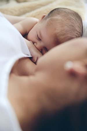 Newborn lying on the bed with her mother