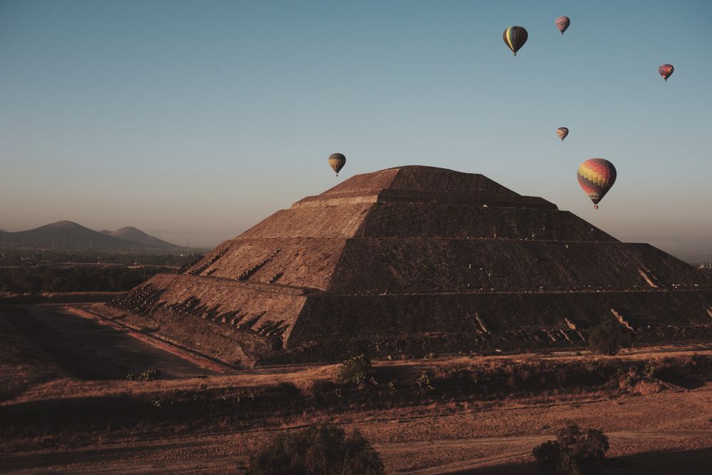 A few hot air balloons in flight over pyramids in Teotihuacan Valley, copy space