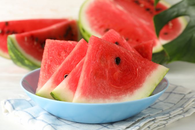 Composition with plate of fresh watermelon on blank wooden background