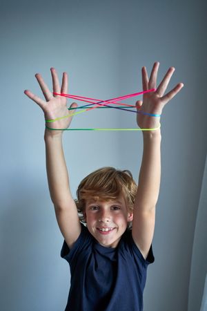 Happy boy playing cats cradle game