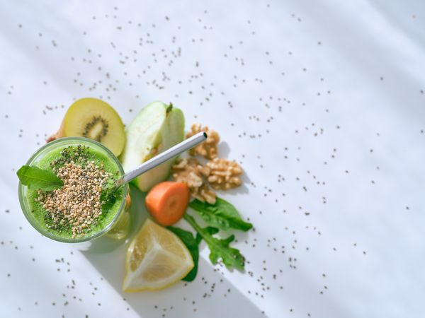 Smoothie with seeds near fruits