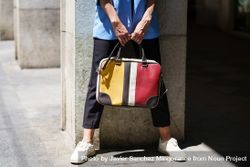 Woman holding colorful computer bag on sunny street 5qkE8p