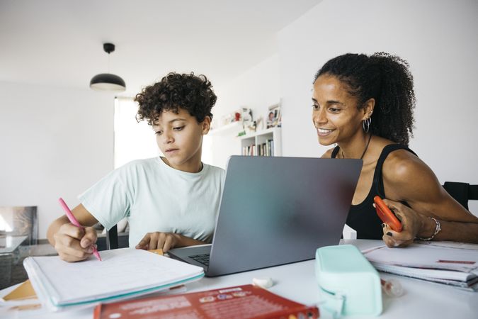 Girl doing her homework with mother