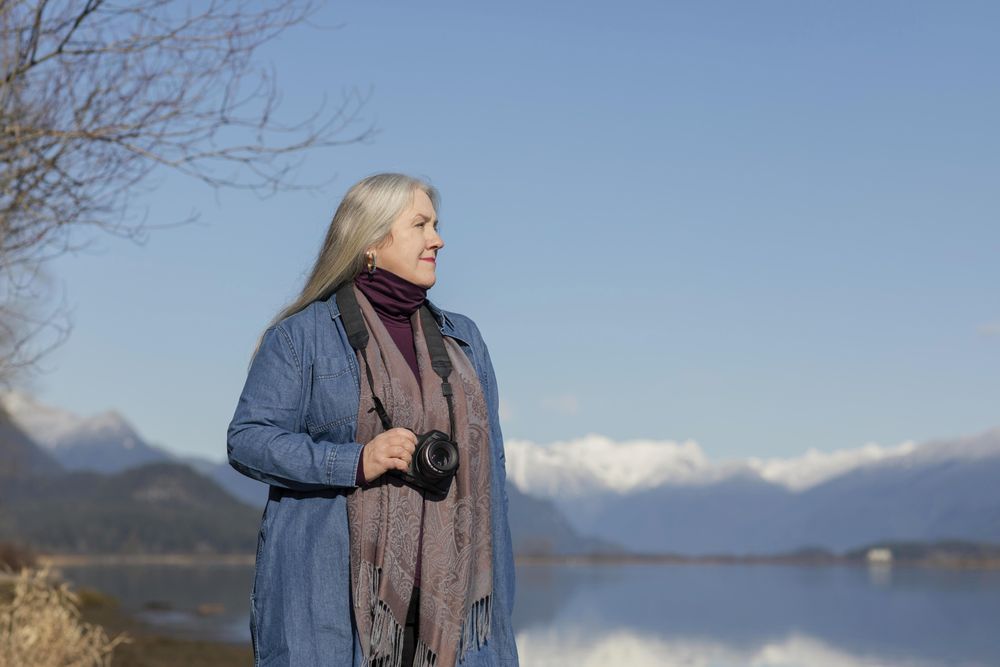 Confident woman holding a camera in nature