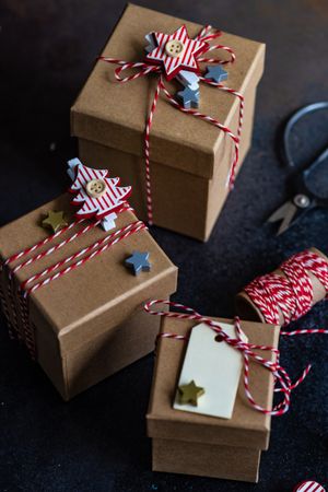 Three brown Christmas gifts with red string