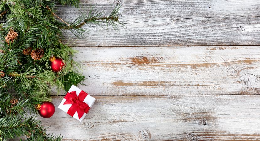 Rough Fir branches and Christmas decorations on rustic wooden background