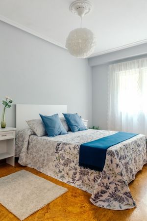 Double bedroom decorated with quilt and curtains