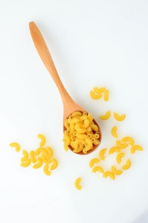 Dried Elbow Macaroni Pasta on Wooden Spoon Over Table