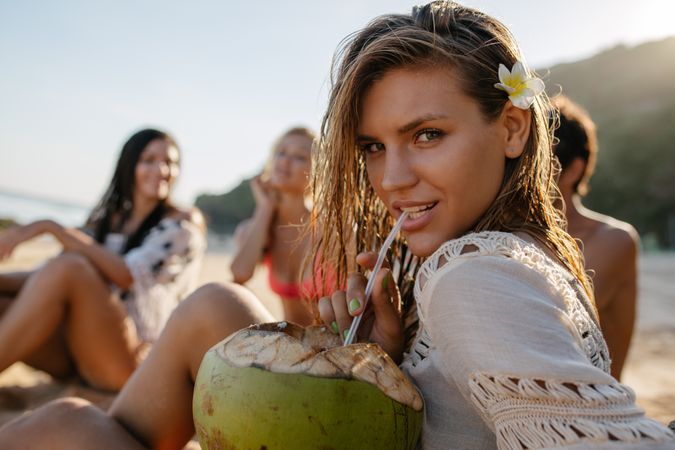 Attractive young woman drinking fresh coconut