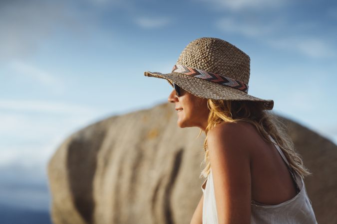 Carefree woman enjoying rest on coast near cliffs