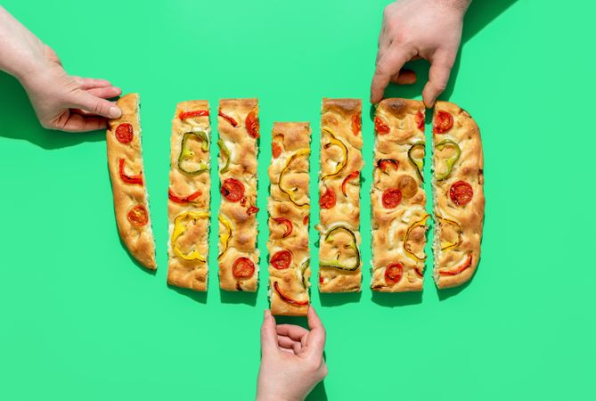 Eating focaccia bread, top view on a green background