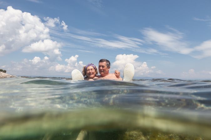 Mature couple swimming together in fresh water